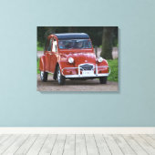 Een oude rode Citroen 2CV auto met een lachende vr Canvas Afdruk (Insitu (Houten vloer))