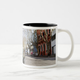 Een oude roestachtige en smaakgeparkeerde autokleu tweekleurige koffiemok