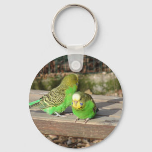 Een paar groene boedgies op een houten bank sleutelhanger