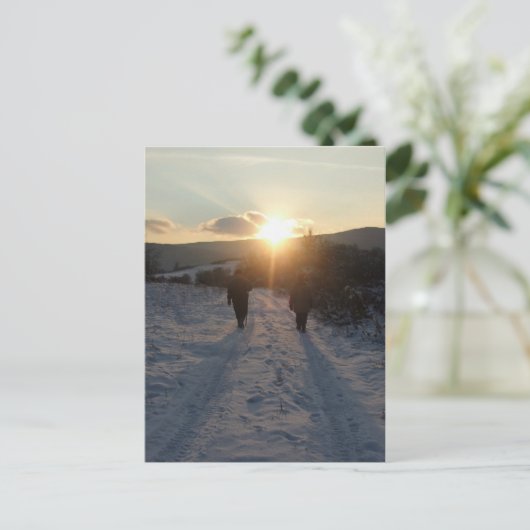 Een paar lopen in de sneeuw bij zonsondergang briefkaart (Staand voorkant)
