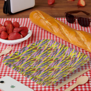 Een pluizige grijze kat met groene ogen zit op een papieren bordje