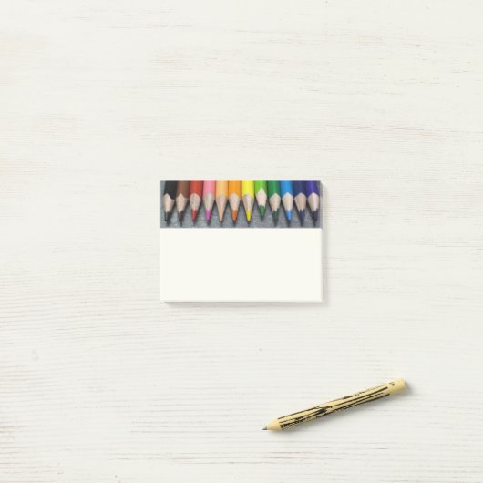 Een rij gekleurde pennen. post-it® notes (Op bureau)