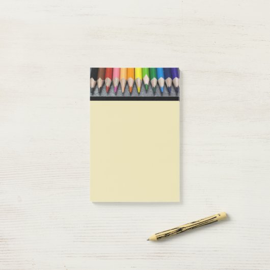 Een rij gekleurde pennen. post-it® notes (Op bureau)