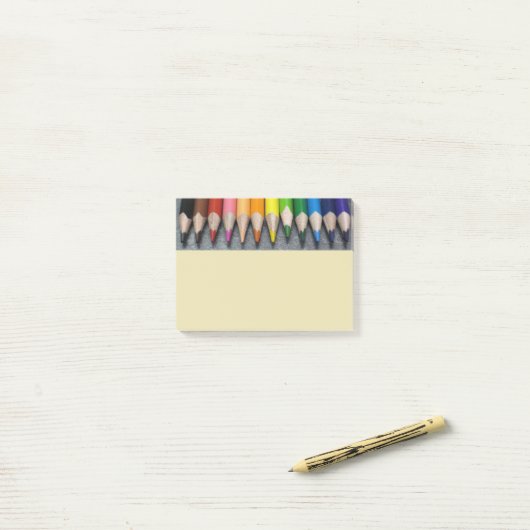 Een rij gekleurde pennen. post-it® notes (Op bureau)