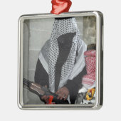 Een rollenspelende vijandelijke agressor bewapent  metalen ornament (Links)