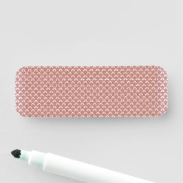 Een roze en witte achtergrond met een patroon naamplaatje
