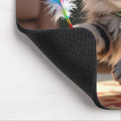 Een Schattigee donzige kat die een veer achterna z Muismat (Hoek)