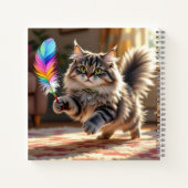 Een Schattigee donzige kat die een veer achterna z Notitieboek (Achterkant)