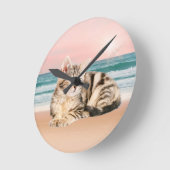 Een Schattigee Gestreepte Kat Zittend op Strand me Ronde Klok (Hoek)