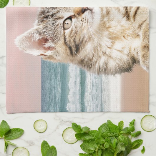 Een Schattigee Gestreepte Kat Zittend op Strand me Theedoek (Gevouwen)