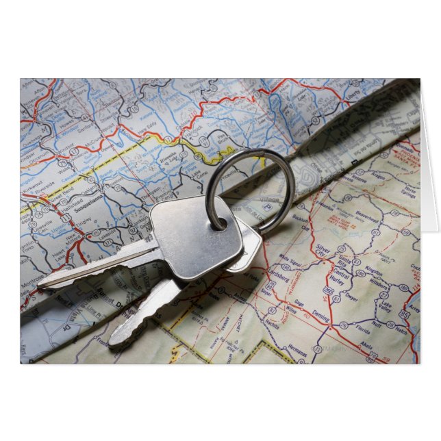 Een set autosleutels op een stapel wegenkaarten. (Voorkant Horizontaal)