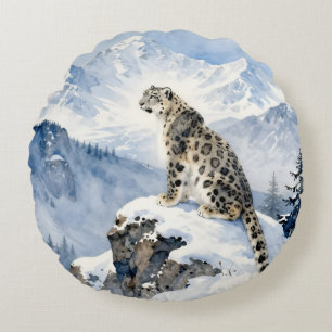 Een sneeuwluipaard op besneeuwde top rond kussen
