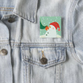 Een sneeuwman die een versiering aan een boom hang vierkante button 5,1 cm (In situ)