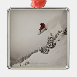 Een snowboarder springt van een klif naar een poed metalen ornament
