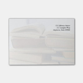 Een stapel oude boeken, één open post-it® notes