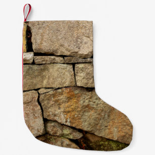 Een stenen muur gemaakt van cobblestenen achtergro kleine kerstsok