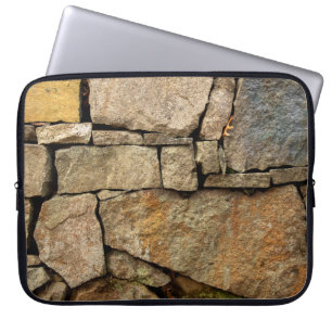Een stenen muur gemaakt van cobblestenen achtergro laptop sleeve