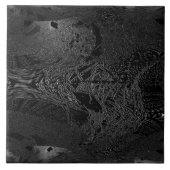 Een stuk donkerzwarte keramiek met een ruimtemater tegeltje (Voorkant)