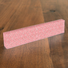 Een tapijt met een rood en roze motief is voorzien naambordje