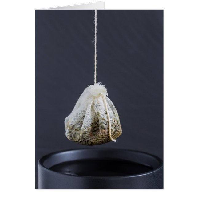 Een theezakje zit in een beker. (Voorkant)