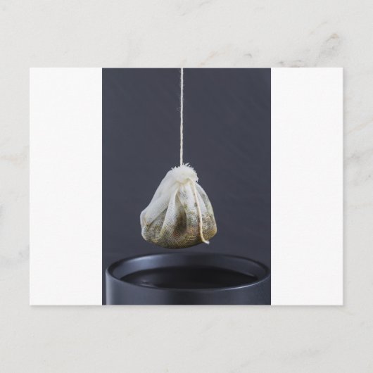 Een theezakje zit in een beker. briefkaart (Voorkant)
