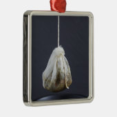 Een theezakje zit in een beker. metalen ornament (Rechts)