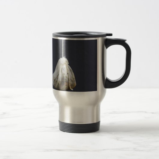 Een theezakje zit in een beker. reisbeker (Rechts)