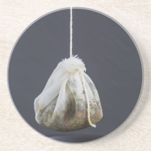Een theezakje zit in een beker. zandsteen onderzetter