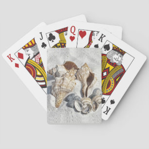 Een verzameling schelpen op zand pokerkaarten