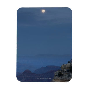 Een volle maan stijgt door een schemerhemel bij Ho Magneet