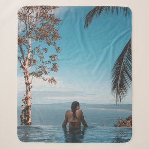 Een vrouw met een zwarte bikini kraan zwemt op het sherpa deken