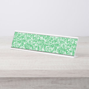 Een weelderige, groene varen met delicate, boogvor bureau naambordje
