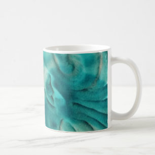 Een wervelend patroon in blauwgroen en lichtbeige koffiemok