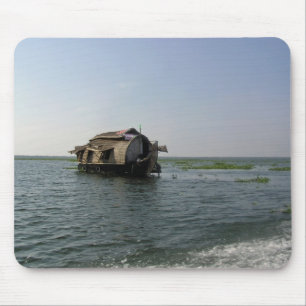 Een woonboot die snel door een kustmeer vaart muismat