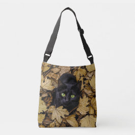 Een zwarte kat speelt in de herfstbladeren crossbody tas