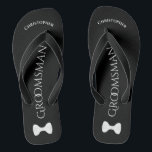 Eenvoudig non Groomsman Name & Bow Stropdas Wedden Teenslippers<br><div class="desc">Deze leuke teenslippers zijn een geweldige manier om de groomsmen te bedanken op je bruiloft, en een geweldige manier om zijn voeten na een lange dag een pauze te geven! Ze hebben een simpel wit op zwart design met zijn naam bovenaan, het woord "Groomsman" in klastige letters in het midden,...</div>