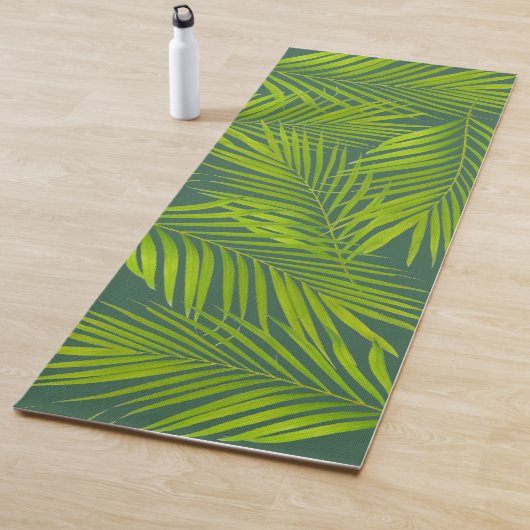 Eenvoudige botanische groene palmbladeren op groen yogamat (In situ)