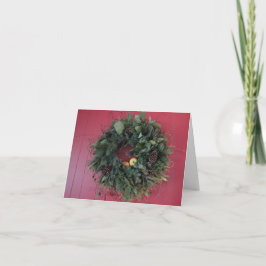 Eenvoudige kerstkrans aan rode muur bedankkaart