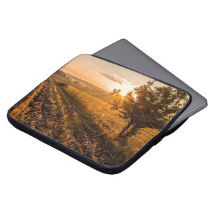 Eenzame boom op het broeiveld in de gouden zonsopg laptop sleeve