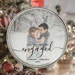 Eerste kerstcadeautje Aangepaste foto Zwart script Metalen Ornament<br><div class="desc">Herdenking je verloving met deze mooie moderne keepaardversiering. De zwarte tekst staat "Ons eerste kerstfeest bezet", met het woord "verloofd" in elegant handschrift met een bloei voor en na. Vervang het afbeelding van de steekproef met uw favoriete foto, en voeg uw namen en het jaar toe. Een witte de hulp...</div>