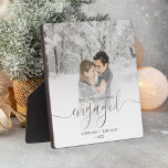 Eerste kerstcadeautje Foto Silver Script Fotoplaat<br><div class="desc">Herdenking je verloving met deze mooie moderne keepaardplak. In de tekst staat: "Onze eerste kerst bezet" met het woord "betrokken" in elegant zilveren foliehandschrift met bloei voor en na de dag. Vervang het afbeelding van de steekproef met uw favoriete foto, en voeg uw namen en het jaar toe. Een witte...</div>