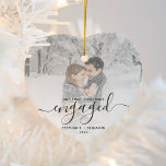 Eerste Kerstmis Aangepast Foto Grijs Manuscript Keramisch Ornament<br><div class="desc">Herinneer je verloving met dit prachtige, hartvormige keepaardse ornament. De grijze tekst leest "Onze eerste kerst bezet, "met het woord "bezeten"in elegant handschrift manuscript met bloei voor en na. Vervang het afbeelding van de steekproef met uw favoriete foto, en voeg uw namen en het jaar toe. Een witte de hulp...</div>