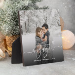 Eerste Kerstmis Aangepaste foto White Script Fotoplaat<br><div class="desc">Herdenking je verloving met deze mooie moderne keepaardplak. De witte tekst leest "Ons eerste Kerstfeest bezet, "met het woord "bezeten"in elegant handschrift manuscript met bloei voor en na. Vervang het afbeelding van de steekproef met uw favoriete foto, en voeg uw namen en het jaar toe. Een zwarte de hulp van...</div>