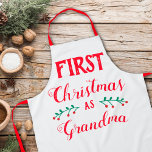 Eerste Kerstmis als oma Schort<br><div class="desc">Dit kerstfeest schort is perfect om de eerste kerst te vieren als grootmoeder. De tekst luidt "Eerste Kerstmis als oma" in moderne rode letters op een witte achtergrond.</div>