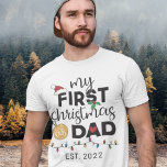 Eerste Kerstmis als vader... familie die schattig  T-shirt<br><div class="desc">Show je plezier voor je allereerste kerstfeest als vader met dit mooie T-shirt met een rode kersthoed,  groene heilige bladeren,  een gouden bal,  een rood hart en kleurrijke kerstlichten.</div>