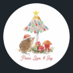 Egel Paddenstoelen Woodland Kerstmis Ronde Sticker<br><div class="desc">Illustratie van een egel die een kerstmuts draagt met champignons versierd met kerstverlichting,  boog,  ster en geschenken. Tekst: "Vrede,  liefde en vreugde"</div>