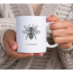 Elegant  bijen koffiemok<br><div class="desc">Deze elegante mok kenmerkt een  zwarte en witte illustratie van een bij,  met een vlek om jouw naam toe te voegen.</div>