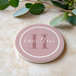 Elegant Dusty Roos Custom Monogram Initiaal Zandsteen Onderzetter<br><div class="desc">Het Elegant ronde gepersonaliseerde ontwerp van het onderzetter van de drink van de drank kenmerkt een klassiek initiaal van de douanesusserif in dusty roos met uw familienaam in modern wit calligrafiemanuscript tegen een lichte mauve/stoffige roze achtergrond van het roos. Een eenvoudige witte cirkel lijst het ontwerp. Het kleurenschema kan worden...</div>