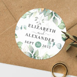 Elegant greenery eucalyptus names en trouwdatum ronde sticker<br><div class="desc">Deze romantische en elegante sticker voor de bloemrijke bruiloft zorgt voor de perfecte afdichting voor uw huwelijksgunst, met een chic botanisch ontwerp dat een klasje van licht en luchtrijke waterverf groene bladeren en eucalyptusbladeren bevat, aangevuld met glitterige gouden enkels (gedrukt) en gemakkelijk te gebruiken met uw namen en trouwdatum. Deze...</div>