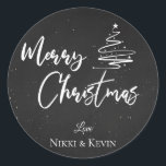 Elegant krijtbord Script Merry Christmas Tree Ronde Sticker<br><div class="desc">Elegant krijtbord Script Merry Christmas Tree Classic ronde Sticker. Pas het aan door de namen te wijzigen. Het ontwerp heeft Merry Christmas in  lettertype geschreven op een krijtbordachtergrond,  samen met de namen van het paar. Voor verdere aanpassing,  voel vrij om me bij mypaperlove2021@gmail.com te contacteren</div>